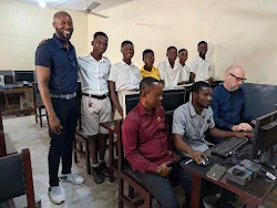 Students and adults gathered around the computers at Liberty School